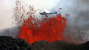Prelet lietadla nad sopkou chrliacou lávu