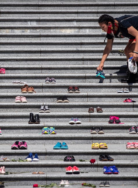 Páry topánok pred kostolom na pamiatku nájdených pozostatkov 215 detí