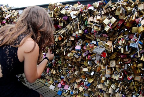 Paríž Pont des Arts most lásky  zámky žena pripevňuje zámok