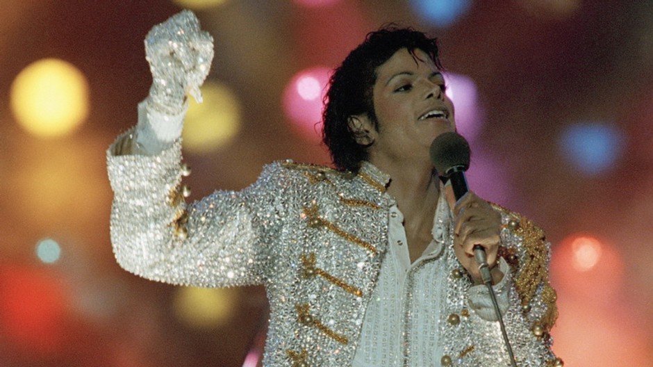 Michael Jackson, koncert, ruka hore, hlava zaklonená, mikrofón, biele sako