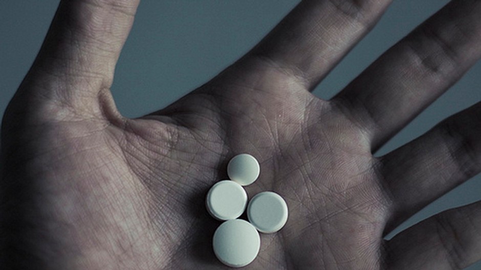 Biele tabletky okrúhle na dlani, ruka