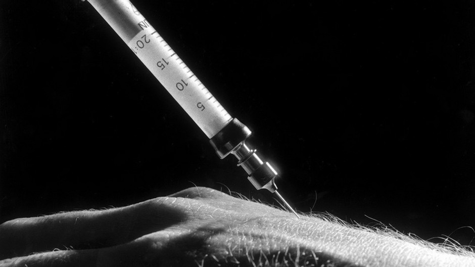 Injekčná striekačka_ruka_čiernobiele foto_ilustračné