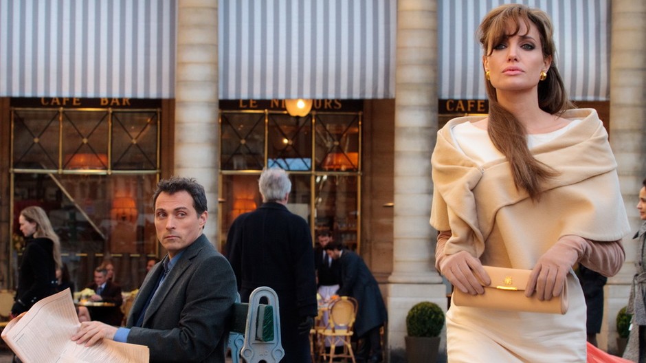 angelina jolie stoji, skormuteny vyraz, muz noviny diva sa na nu