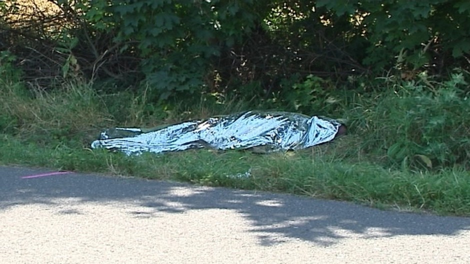 mrtvola prikryta igelitom, saklom na trave vedla cesty
