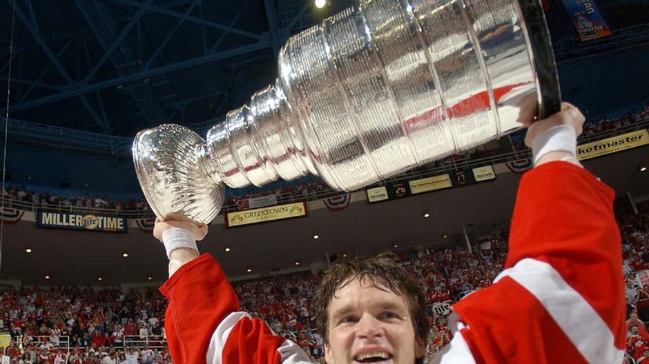hokejista drzi v rukach na ihrisku stanleyho pohar