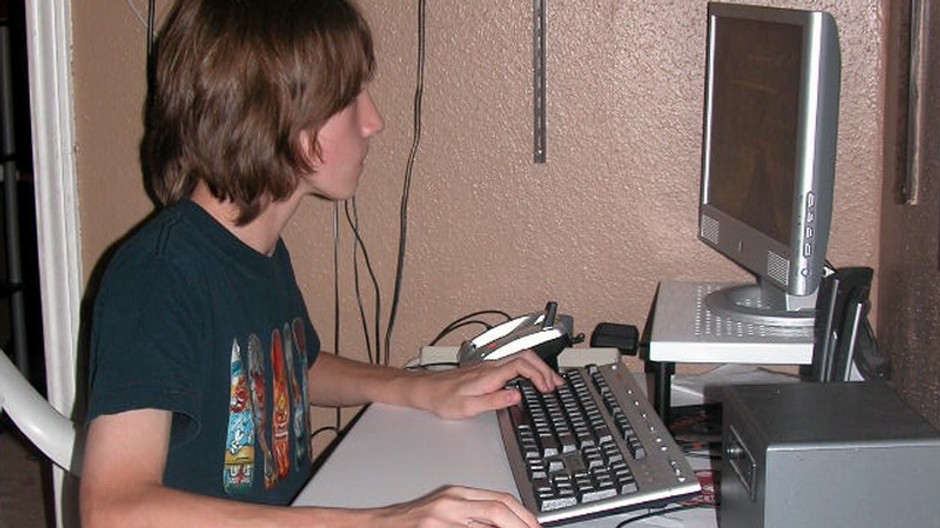 mlady chlapec na pocitaci zboku