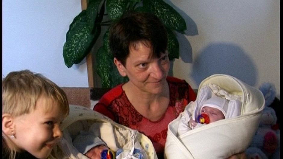 Žena s dvojčatami v náručí