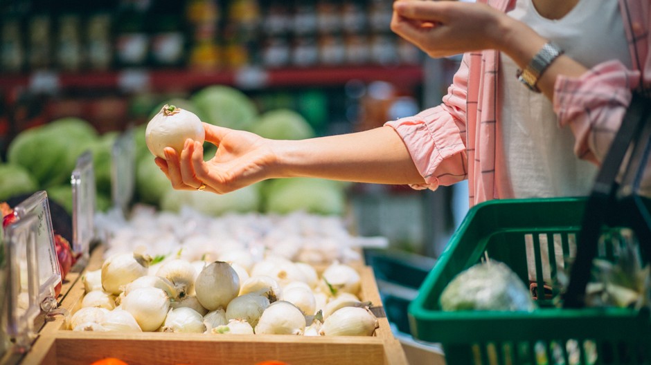 Zena drzi cibulu v obchode